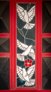 Colorful stained glass window featuring birds as part of an artistic design