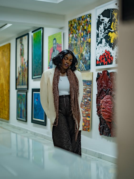 A woman standing in a private collection space with artwork displayed on the walls behind her