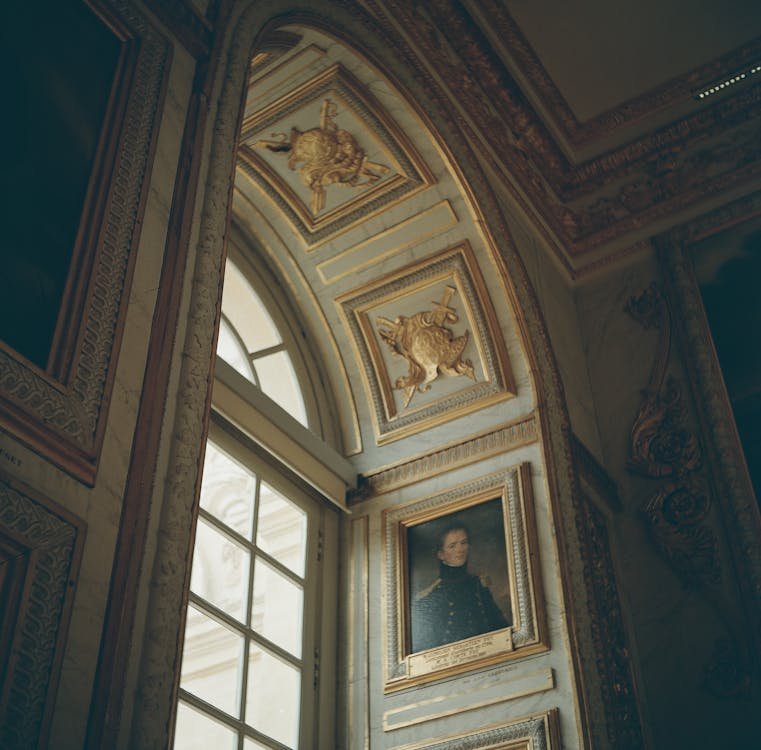 A gold-framed portrait painting and ornate architectural details inside a historic estate.