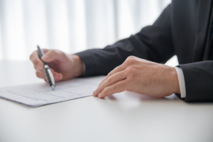 A professional in a suit reviewing documents related to artwork valuation or an appraisal report