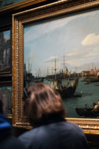A man walking through an art gallery, observing displayed artworks