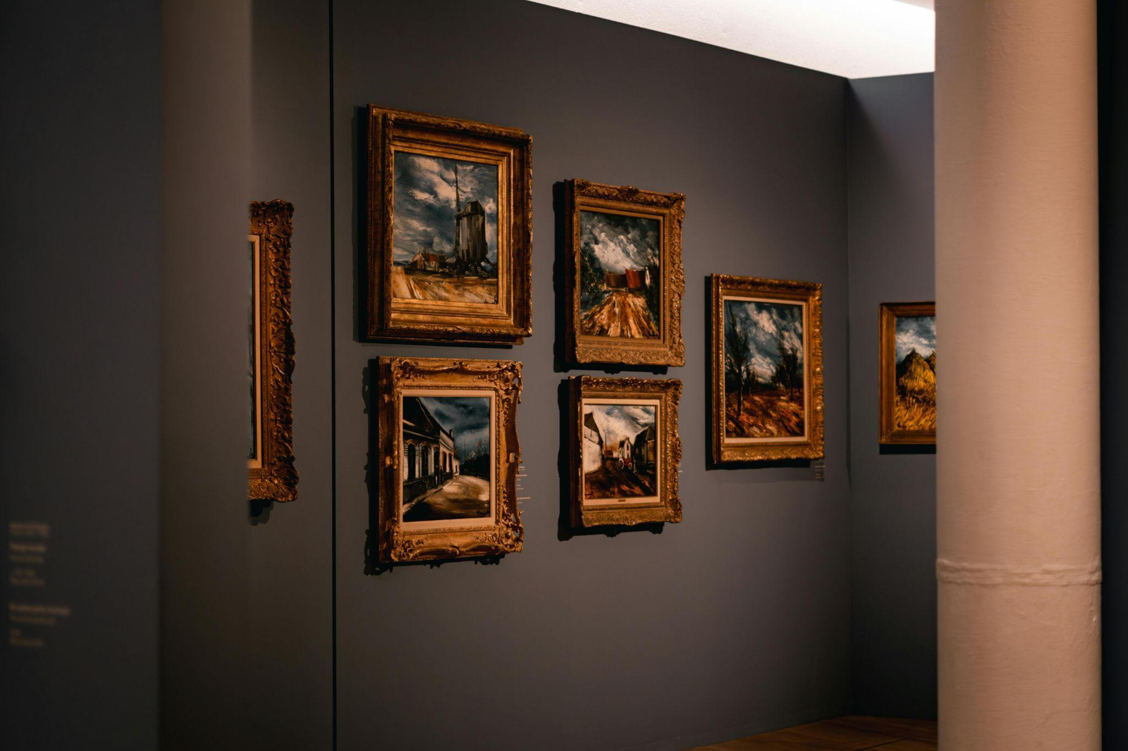 a collection of artwork on display on a wall